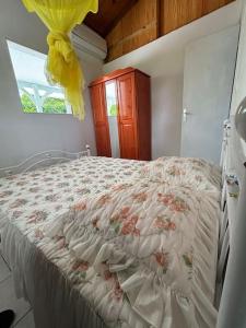 a bedroom with a bed with a white comforter and a window at Le pain de sucre maison de campagne sainte marie in Sainte-Marie