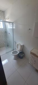 a white bathroom with a toilet and a shower at Casa Paraiso da Montanha in São Thomé das Letras +5 photos