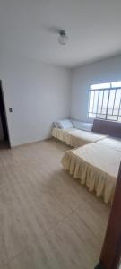 a room with two beds in it with a window at Casa Paraiso da Montanha in São Thomé das Letras