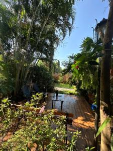 eine Holzterrasse mit einer Bank im Garten in der Unterkunft Posada Portal del Iguazu in Puerto Iguazú