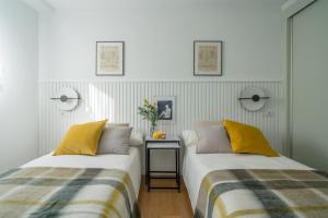 Duas camas sentadas uma ao lado da outra num quarto em AkomodaT en luminoso y acogedor cercano a la playa y Bilbao em Urduliz