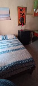 a bedroom with a bed and a painting on the wall at Hugo's Relax Home (Casa) in Ayangue