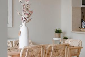 stół jadalny z krzesłami i wazon z kwiatami w obiekcie Modern Villa in El Gouna (Private Pool & Garden.) w mieście Hurghada