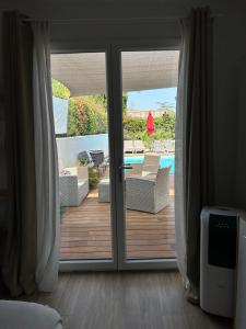 a sliding glass door leading to a patio with a pool at STUDIO avec PISCINE in Carmaux