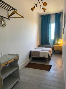 - une chambre avec un lit et des rideaux bleus dans l'établissement CasaCholina, à Santa Cruz de Tenerife