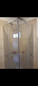 Una cabina de ducha con puertas de cristal en un baño. en Cabañas la victoria, en La Falda