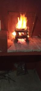 Un horno de ladrillo con fuego. en Cabañas la victoria, en La Falda