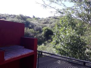 un banco sentado en un balcón con vistas en Cabañas la victoria, en La Falda