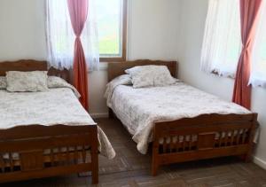 a bedroom with two beds and a window at El Sauce in Curacaví