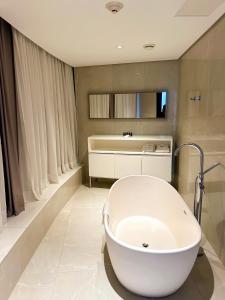 La salle de bains est pourvue d'une baignoire blanche et d'un lavabo. dans l'établissement Propriedade privada no Hotel Nacional Rio de Janeiro, à Rio de Janeiro