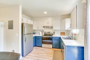 a kitchen with white appliances and blue cabinets at Airy Fortuna Apartment with Deck! in Fortuna