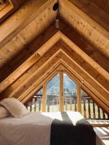 a room with a bed in a roof with a window at Ca de Palomera Vall d’Aran in Les