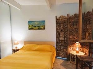 a bedroom with a yellow bed and a wooden gate at Antibes Port de Salis Appart 3p in Antibes