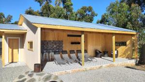 ein Gebäude mit Stühlen und einem Kamin in der Unterkunft Cabaña 4-6 personas con piscina in Algarrobo