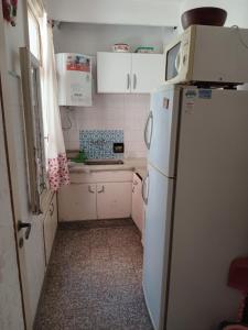 a small kitchen with a refrigerator and white cabinets at depto pleno centro a 3 cuadras del mar in Mar del Plata