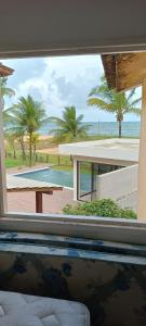 a view of the beach from a window of a house at Chalé Barra Sirinhaém in Sirinhaém