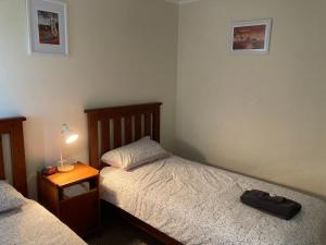 a bedroom with two beds and a lamp on a night stand at Home & Away St Leonards in Saint Leonards