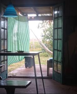 a table in front of a patio with a window at Colibrí in Barra de Valizas