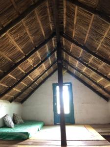 a room with two beds and a window in a roof at Colibrí in Barra de Valizas