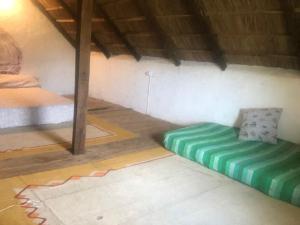 a room with a bed and a couch in it at Colibrí in Barra de Valizas