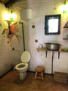 a bathroom with a toilet and a sink at Colibrí in Barra de Valizas