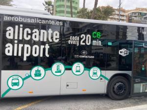 a white bus is parked on the street at Apartment San Carlos Alicante II in Alicante