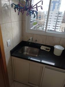 un lavandino da cucina e una finestra con vista sulla città di APARTAMENTO SOLAR DA PRAÇA, Aconchegante e Climatizado a Torres