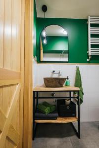 uma casa de banho com um lavatório e uma parede verde em Nasza Chata em Duszniki Zdrój