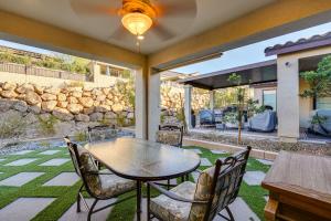 Gorgeous Henderson Home with Patio and Yard! في لاس فيغاس: فناء مع طاولة وكراسي وجدار حجري