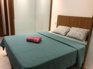 - un lit avec un oreiller rouge dans l'établissement Apartamento Pérola - Zona Sul de Ilhéus - 200 m da praia, à Ilhéus 11 autres photos