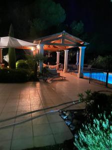 a gazebo with a pool at night at Maison de Golfeur in Mallemort