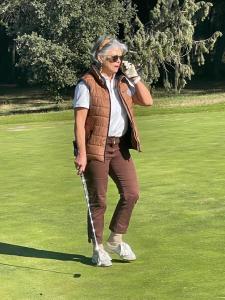 un hombre parado en un campo de golf hablando por celular en Maison de Golfeur en Mallemort