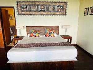 a bedroom with a large bed with two pillows at Latui Lodge in Savusavu