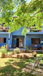 una casa blu con due sedie a sdraio davanti di Casa aconchegante térrea à 3min de carro do centro e praia central a Garopaba