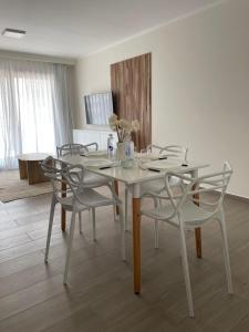 a white dining room table with chairs and flowers on it at EN EL CENTRO DE LOBOS in Lobos +24 photos