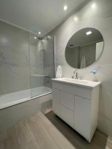 a white bathroom with a sink and a mirror at EN EL CENTRO DE LOBOS in Lobos