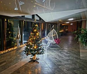 ein Weihnachtsbaum mitten in einer Lobby in der Unterkunft Glory in Truskawez