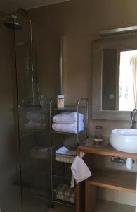 ein Bad mit einer Dusche, einem Waschbecken und Handtüchern in der Unterkunft La casa rossa in Saint-Riquier-ès-Plains
