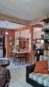 a living room and kitchen with a table and chairs at Casa aconchegante térrea à 3min de carro do centro e praia central in Garopaba