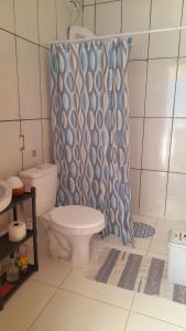uma casa de banho com um WC e uma cortina de chuveiro em Casa aconchegante térrea à 3min de carro do centro e praia central em Garopaba