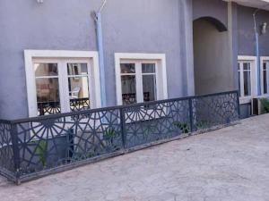 a fence in front of a building with windows at CORAL PLACE in Abeokuta