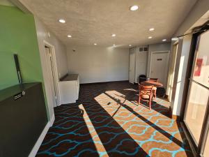 um corredor com um quarto com uma mesa e um tapete em TRAVEL INN em Brandon