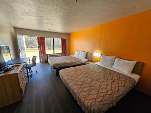 um quarto de hotel com duas camas e uma secretária em TRAVEL INN em Brandon