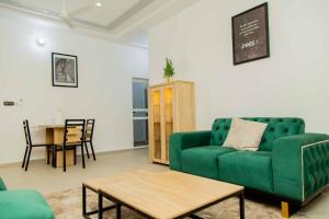 un soggiorno con divano verde e tavolo di Toutfrais1 a Agonkamè