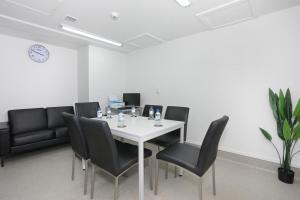 una sala de reuniones con una mesa blanca y sillas negras en Quality Suites Central Square en Palmerston North