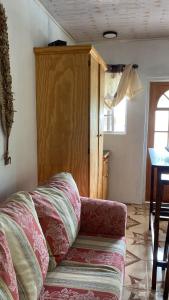 Cool Breeze Suites في Union Island: أريكة في غرفة معيشة مع خزانة خشبية