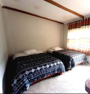 1 dormitorio con 2 camas y ventana en Lucmabamba Lodge, en Santa Teresa