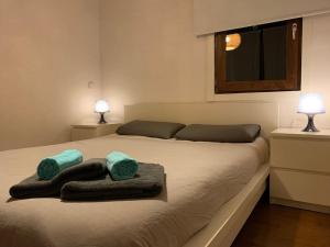 a bedroom with a large bed with towels on it at La Cata Country House in Patones
