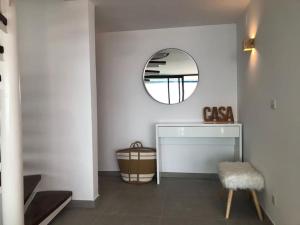 ein weißes Zimmer mit einem Spiegel und einem Tisch in der Unterkunft Joan Timoneda Agradable villa con vistas al mar y 2 parking in Roses
