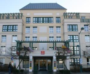 a large building with a sign on the front of it at Appartement proche Disneyland, Val d'Europe, Paris #2 in Serris